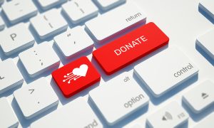Red donate button on white keyboard