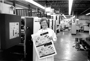 Barbara Roche holding printer proof of first cover of Horizons, which featured kites